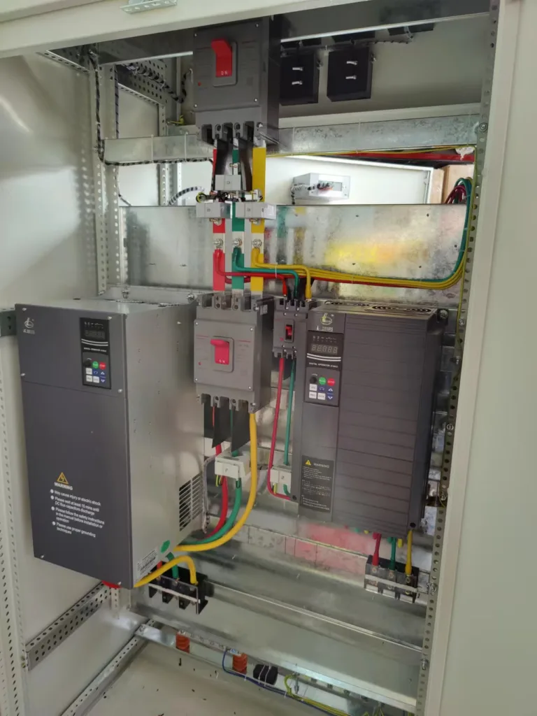 Interior view of an electrical control cabinet showing an OULU EV510A series drive, illustrating a typical installation of a VFD in HVAC system.