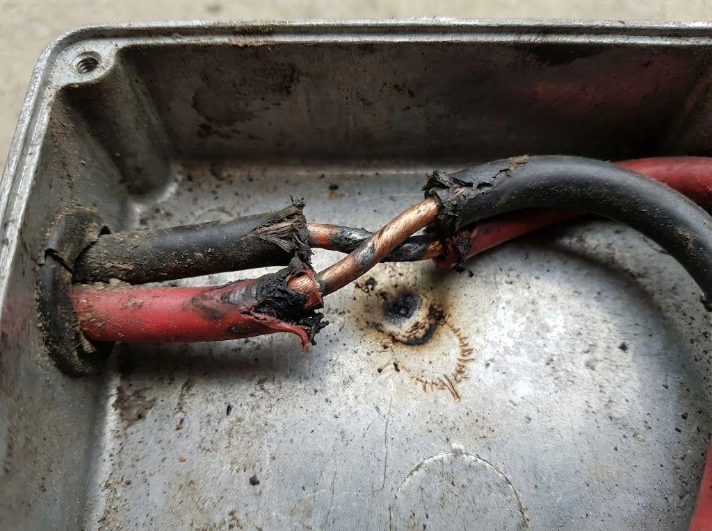 Damaged motor cables creating a phase-to-phase short circuit, a primary cause of VFD overcurrent faults.